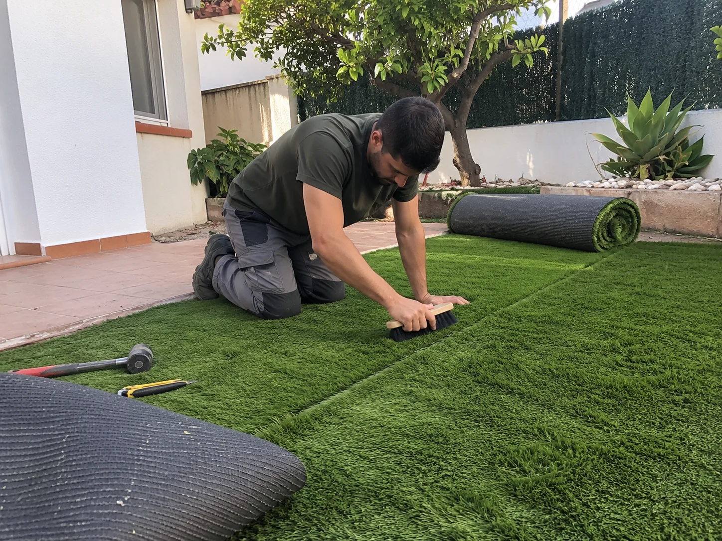 Instalador ajustando las uniones del césped artificial